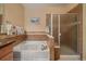 Bathroom with a soaking tub, shower with glass door, and a towel rack with decorative tile at 22124 E Euclid Dr, Aurora, CO 80016