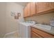 Bright laundry room offers a washer and dryer, storage cabinets, a sink, and tile flooring at 22124 E Euclid Dr, Aurora, CO 80016