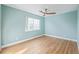 Light-filled bedroom featuring wood floors, neutral paint, and a ceiling fan at 290 Poplar St # A, Denver, CO 80220