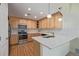 Well-lit kitchen featuring wood cabinets, stainless steel appliances, and stylish white quartz countertops at 290 Poplar St # A, Denver, CO 80220