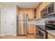 Bright kitchen with stainless steel appliances, wood cabinets, and tiled backsplash at 290 Poplar St # A, Denver, CO 80220