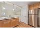 Kitchen with stainless steel refrigerator, pendant lights, and view to living room at 290 Poplar St # A, Denver, CO 80220