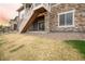 View of backyard with brick siding and a set of stairs to an upper-level patio at 22364 E Bailey Pl, Aurora, CO 80016