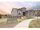 Charming two-story home with a stone facade, gray siding, two-car garage, and a welcoming walkway and beautiful sunset at 22364 E Bailey Pl, Aurora, CO 80016