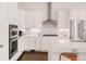 Modern kitchen with stainless steel appliances, white cabinets and countertops, and dark wood floors at 22364 E Bailey Pl, Aurora, CO 80016