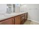 Bathroom featuring double sinks, wood cabinets and a large mirror, providing functionality at 1601 Venice Ln, Longmont, CO 80503