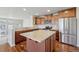 Well-lit kitchen featuring an island, stainless steel appliances, tile backsplash and wood floors at 1601 Venice Ln, Longmont, CO 80503