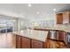 Open kitchen featuring an island, stainless steel appliances, tile backsplash and hardwood floors at 1601 Venice Ln, Longmont, CO 80503