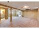 Unfinished basement space with retro wood paneling, tiled floors, and large windows at 11203 W Dorado Ave, Littleton, CO 80127