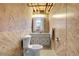 Small bathroom with retro wood paneling and white fixtures at 11203 W Dorado Ave, Littleton, CO 80127
