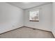 Bedroom featuring neutral carpet, white walls, and a bright window with mini blinds at 11203 W Dorado Ave, Littleton, CO 80127