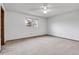 Spacious bedroom featuring neutral carpet, white walls, a ceiling fan, and a bright window at 11203 W Dorado Ave, Littleton, CO 80127