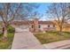 Charming home with a stone chimney, attached garage, and well-kept front lawn at 11203 W Dorado Ave, Littleton, CO 80127