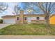 Charming single-story home with a stone chimney, well-manicured lawn, and a two-car garage at 11203 W Dorado Ave, Littleton, CO 80127