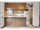 Close-up shot of the kitchen with wood cabinets and access to the breakfast bar and entry to the home at 11203 W Dorado Ave, Littleton, CO 80127