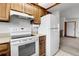 Bright kitchen offering wood cabinets, laminate countertops, electric range, and white refrigerator at 11203 W Dorado Ave, Littleton, CO 80127