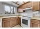 Well-lit kitchen featuring wood cabinets, laminate countertops, and a view of backyard through the window above the sink at 11203 W Dorado Ave, Littleton, CO 80127