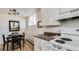 Compact kitchen features white cabinets, a dining table, and plenty of natural light at 1525 S Holly St # 106, Denver, CO 80222