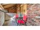 Cozy patio featuring brick accents, red chairs and a small table near a window at 1525 S Holly St # 106, Denver, CO 80222