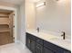 Bathroom with double sinks, a vanity, modern fixtures, and a door leading to the closet at 5550 Wetlands Dr, Longmont, CO 80504