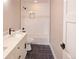 Bathroom with dual sink vanity, dark tile floor, and shower-tub with white tile and mosaic accent at 5550 Wetlands Dr, Longmont, CO 80504