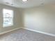 An empty bedroom has neutral colored walls and carpet, a window to the outside, and speaker in the ceiling at 5550 Wetlands Dr, Longmont, CO 80504