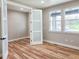 Bedroom with ample natural light from two large windows, wood flooring, and white doors at 5550 Wetlands Dr, Longmont, CO 80504