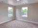 Bedroom with neutral carpet and walls, recessed lighting, and two windows overlooking neighborhood at 5550 Wetlands Dr, Longmont, CO 80504