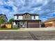 Two-story home featuring stone accents, a modern garage door, and a well-manicured lawn at 5550 Wetlands Dr, Longmont, CO 80504