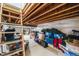 Basement storage area with exposed ceiling beams, ample storage containers, and shelving at 9694 Meeker St, Littleton, CO 80125
