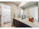 Well-lit bathroom with a marble countertop, dark wood cabinets, and an adjacent shower at 9694 Meeker St, Littleton, CO 80125