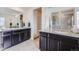 Modern bathroom featuring double vanities with stone countertops and a large mirror, creating a luxurious space at 9694 Meeker St, Littleton, CO 80125