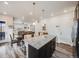 Bright, open kitchen featuring a center island with bar seating, dark cabinets, and recessed lighting at 9694 Meeker St, Littleton, CO 80125