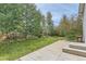 Backyard with a concrete patio and tall aspen trees along the wooden fence at 162 N Eaton Park St, Aurora, CO 80018