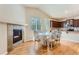 Bright dining area featuring a fireplace, wood floors, and an adjacent kitchen with modern appliances at 162 N Eaton Park St, Aurora, CO 80018