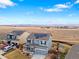 An aerial view highlights a neighborhood with homes, solar panels, and mountain views in the distance at 7131 Shavano Cir, Frederick, CO 80504