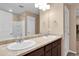 Bathroom with dual sinks, neutral color palette, and well-lit vanity area at 7131 Shavano Cir, Frederick, CO 80504