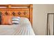 Close up of a bed with decorative pillows and unique wood headboard detailing at 7131 Shavano Cir, Frederick, CO 80504