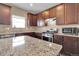 Modern kitchen featuring granite countertops, stainless steel appliances, and dark wood cabinetry at 7131 Shavano Cir, Frederick, CO 80504