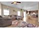 Spacious living room featuring hardwood floors, large windows, and comfortable seating flowing into the dining area at 7131 Shavano Cir, Frederick, CO 80504