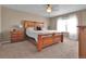 Warm and inviting main bedroom featuring a wooden bed frame, soft carpet, and natural light from the window at 7131 Shavano Cir, Frederick, CO 80504