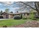 Single-story home with a brick exterior, well-manicured lawn, mature trees, and a driveway leading to an attached garage at 1164 W 101St Pl, Northglenn, CO 80260