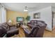 Cozy living room featuring hardwood floors, comfortable leather seating, and a ceiling fan at 1164 W 101St Pl, Northglenn, CO 80260
