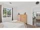 Sunlit bedroom features dual wood dressers, a leafy backyard view and easy access to the main living area at 4085 S Crystal Cir # 101, Aurora, CO 80014