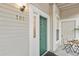 Charming unit entrance with a green door, gold numbers, and outdoor seating area at 4085 S Crystal Cir # 101, Aurora, CO 80014