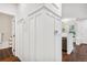 Hallway with dark wood floors and white wainscoting leading to the living area and bathroom at 4085 S Crystal Cir # 101, Aurora, CO 80014