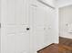 Hallway with hardwood floors, double closets, and bathroom with geometric-patterned tile flooring at 4085 S Crystal Cir # 101, Aurora, CO 80014