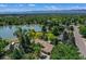 Breathtaking aerial view of a lakeside home surrounded by lush greenery and distant mountain views at 4790 W Lakeridge Rd, Denver, CO 80219
