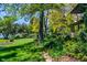 Sprawling lawn is beautifully landscaped with mature trees and lake views at 4790 W Lakeridge Rd, Denver, CO 80219