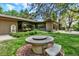 Tranquil backyard featuring a unique stone fire pit, lush landscaping, and an inviting outdoor atmosphere at 4790 W Lakeridge Rd, Denver, CO 80219